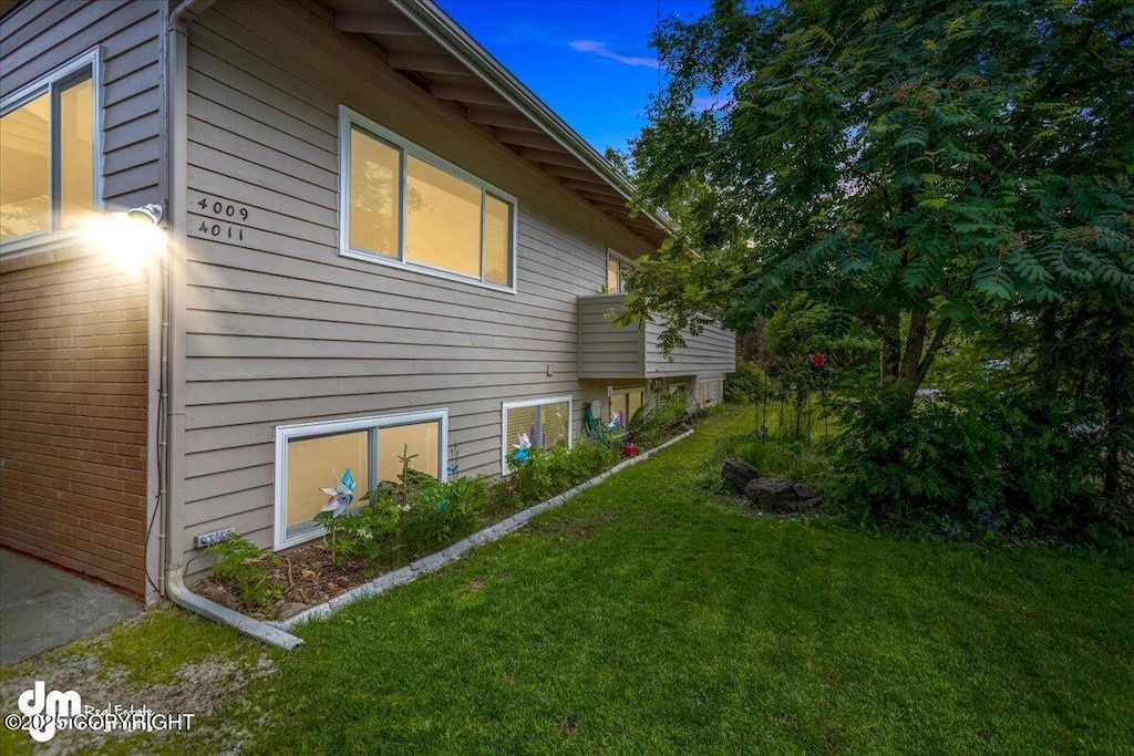 view of side of home with a yard