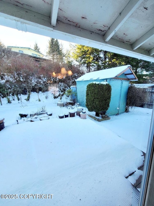 yard layered in snow with a shed