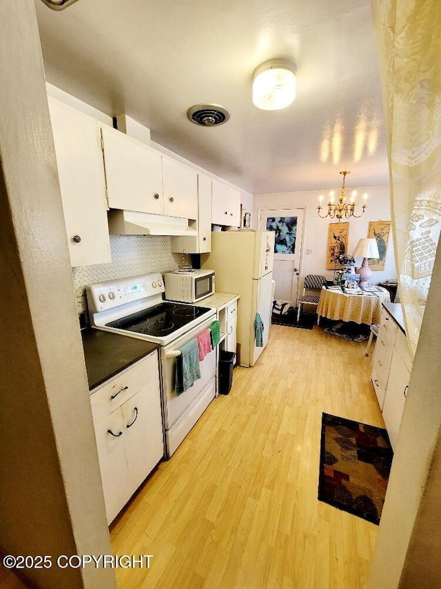 kitchen featuring pendant lighting, white appliances, white cabinetry, a notable chandelier, and light wood-type flooring