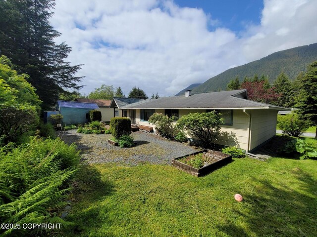 223 Lakeview Dr, Sitka, AK 99835 - rear view of house featuring a yard, a garden, and a mountain view