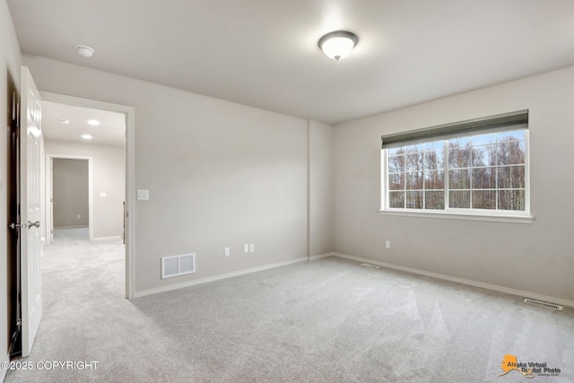 empty room with carpet floors, visible vents, and baseboards