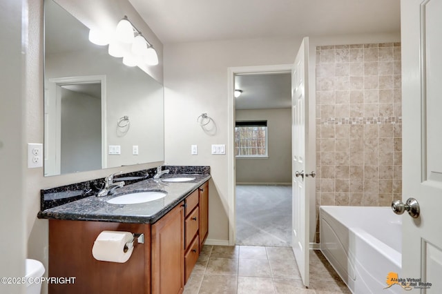 full bath featuring double vanity, baseboards, a sink, and tile patterned floors