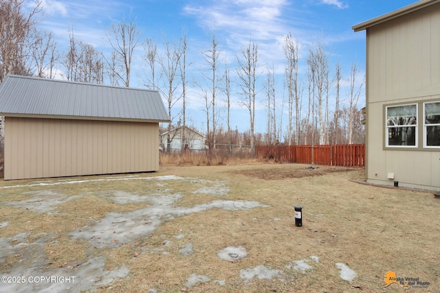 view of yard with fence and an outdoor structure