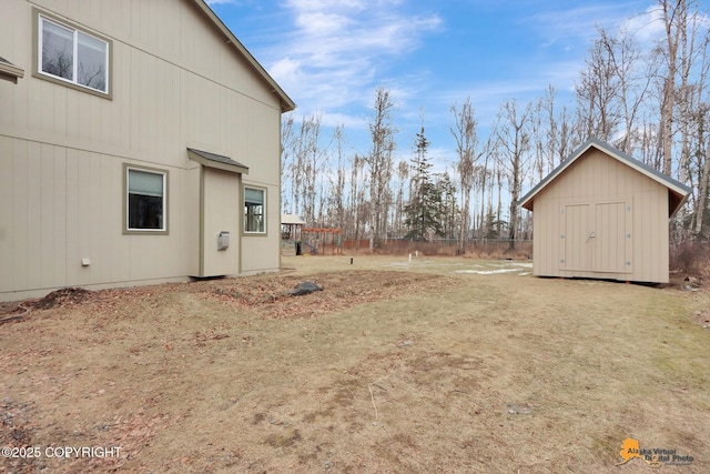 view of yard with an outbuilding, fence, and a shed