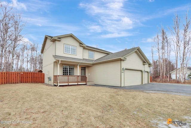 traditional home with roof with shingles, fence, a deck, a garage, and driveway