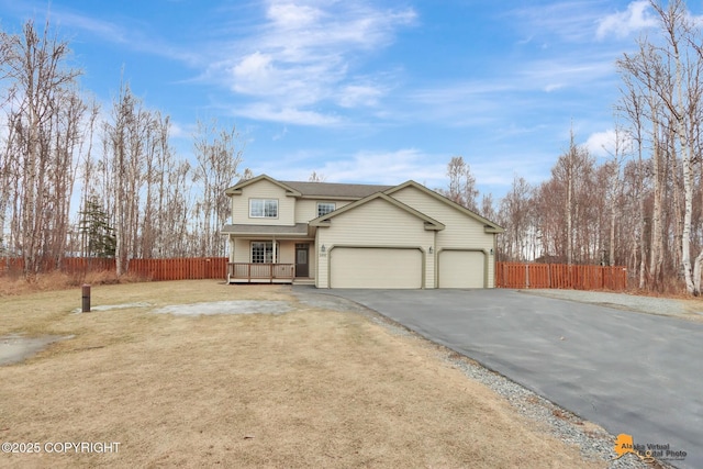 view of front of house with a garage, driveway, and fence