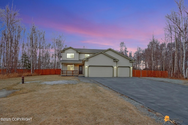 view of front of property featuring a garage, aphalt driveway, a porch, and fence