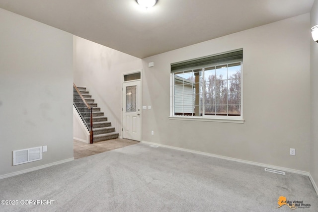 interior space with carpet, visible vents, stairway, and baseboards