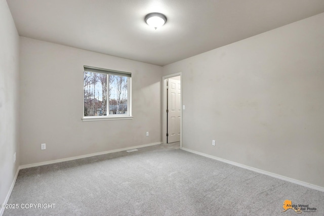 empty room featuring carpet floors and baseboards