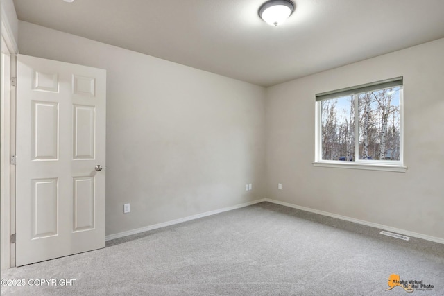 carpeted empty room with visible vents and baseboards