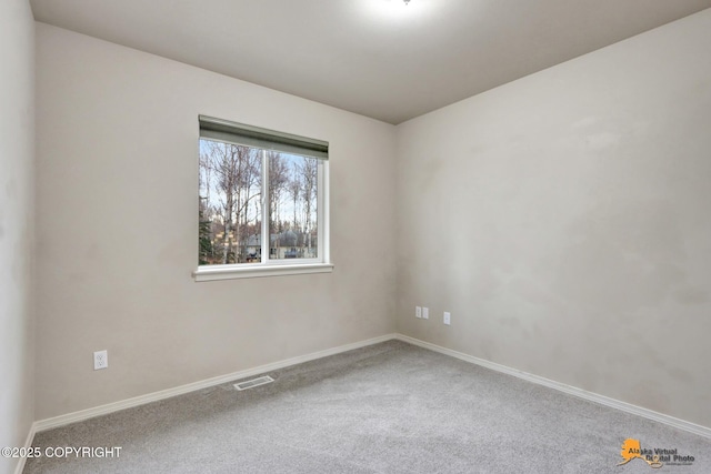 unfurnished room with baseboards, visible vents, and carpet flooring