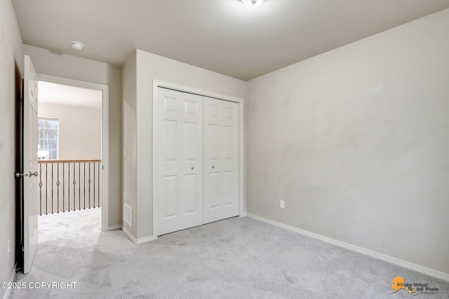 unfurnished bedroom with a closet, carpet flooring, and baseboards