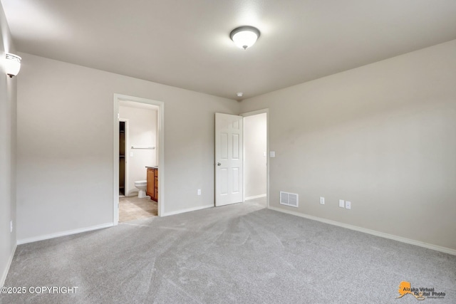 unfurnished bedroom with carpet, visible vents, connected bathroom, and baseboards