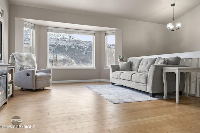 living room featuring a mountain view, a chandelier, and light hardwood / wood-style flooring