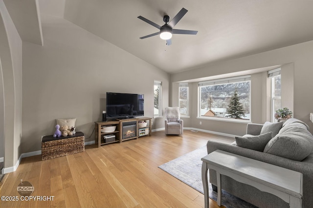 living room featuring lofted ceiling, light hardwood / wood-style flooring, and ceiling fan