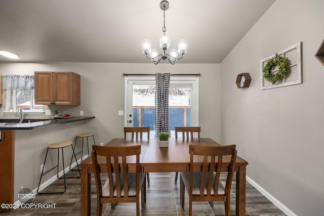 dining area featuring plenty of natural light, dark hardwood / wood-style floors, vaulted ceiling, and a notable chandelier