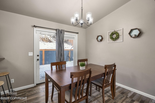 dining area with dark wood-type flooring, vaulted ceiling, and a chandelier