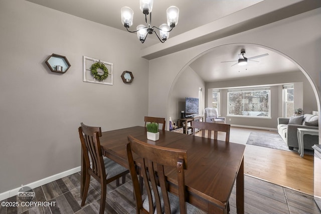 dining space with ceiling fan with notable chandelier and hardwood / wood-style floors