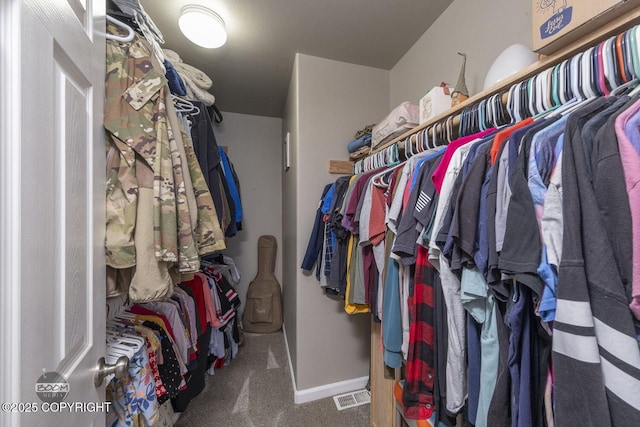 walk in closet featuring dark carpet