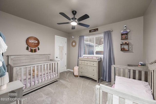 carpeted bedroom with a nursery area and ceiling fan