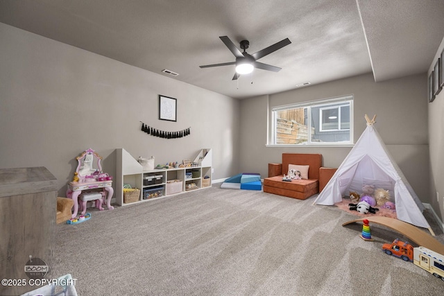 game room featuring carpet floors, a textured ceiling, and ceiling fan