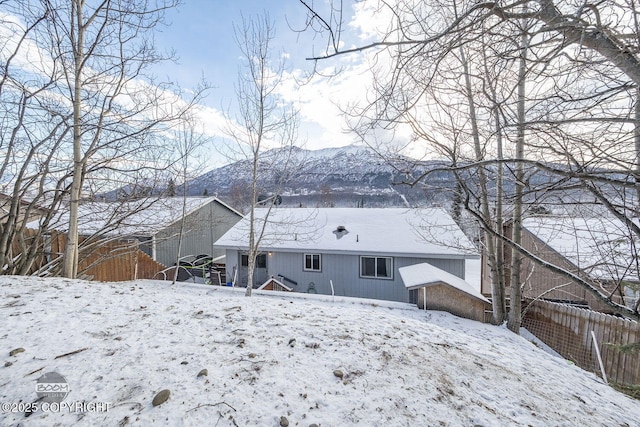 snow covered back of property with a mountain view