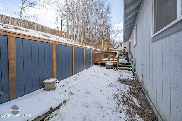 yard layered in snow featuring a wooden deck