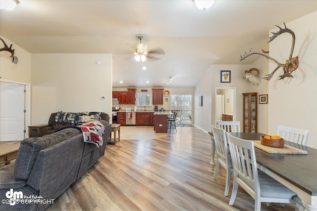 living room with light hardwood / wood-style floors, lofted ceiling, ceiling fan, and sink