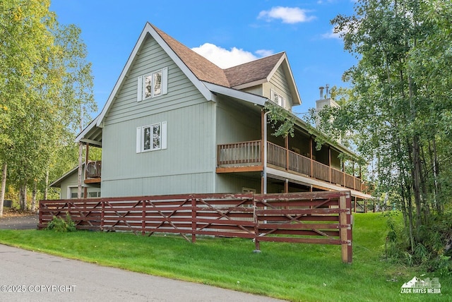 view of side of property with a balcony and a yard