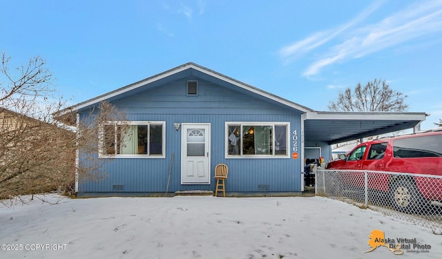 view of front of home featuring an attached carport, crawl space, and fence