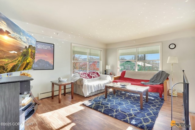 living area featuring plenty of natural light, a baseboard radiator, and wood finished floors