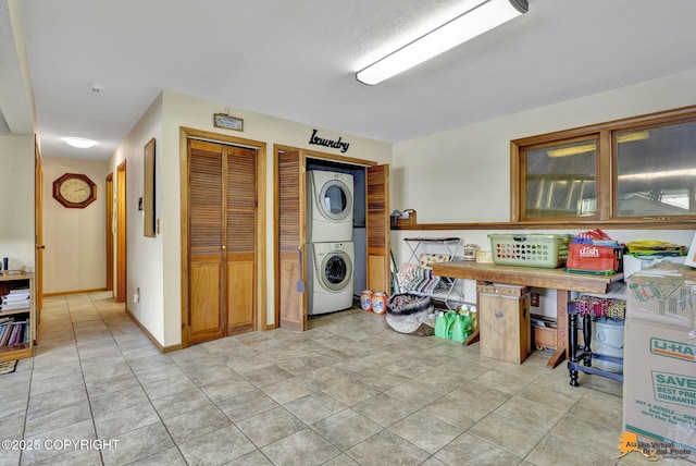 interior space with stacked washer / drying machine and light tile patterned floors