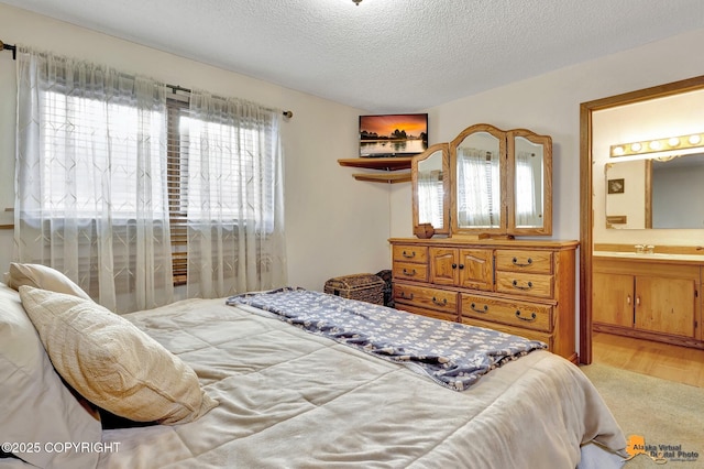 bedroom with ensuite bath and a textured ceiling