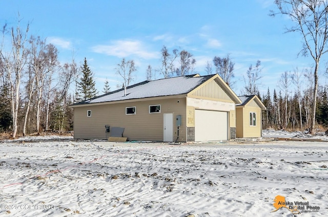 snow covered property featuring a garage