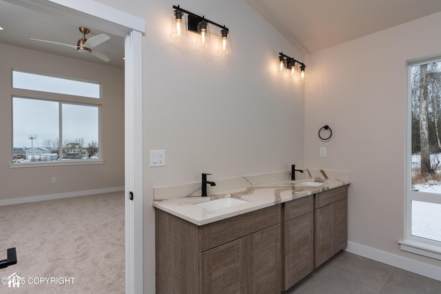 bathroom with vaulted ceiling, double vanity, a sink, and a ceiling fan