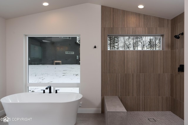 bathroom featuring baseboards, tiled shower, vaulted ceiling, a freestanding bath, and recessed lighting
