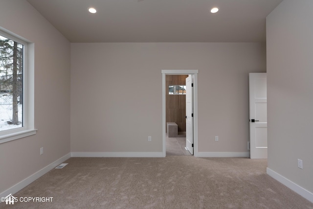 unfurnished bedroom featuring recessed lighting, light colored carpet, visible vents, and baseboards