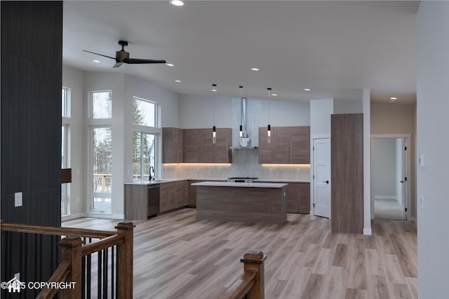 kitchen with modern cabinets, a kitchen island, light countertops, and decorative light fixtures