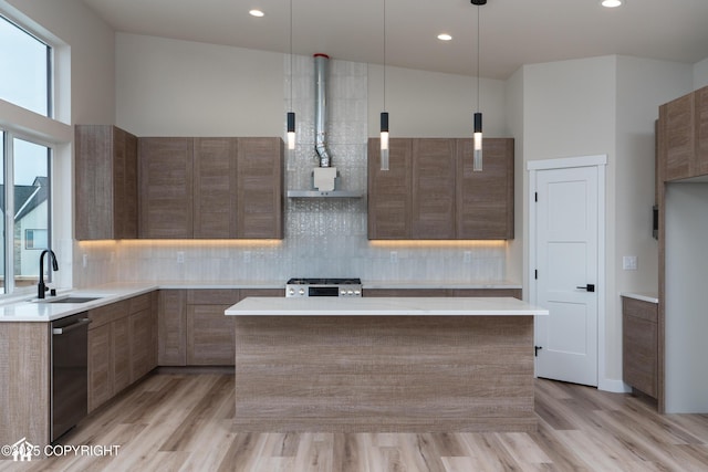 kitchen with decorative light fixtures, light countertops, stainless steel dishwasher, a sink, and modern cabinets
