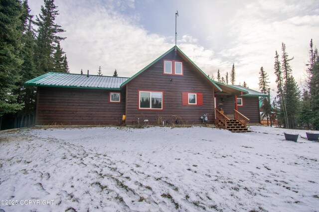 snow covered back of property with metal roof