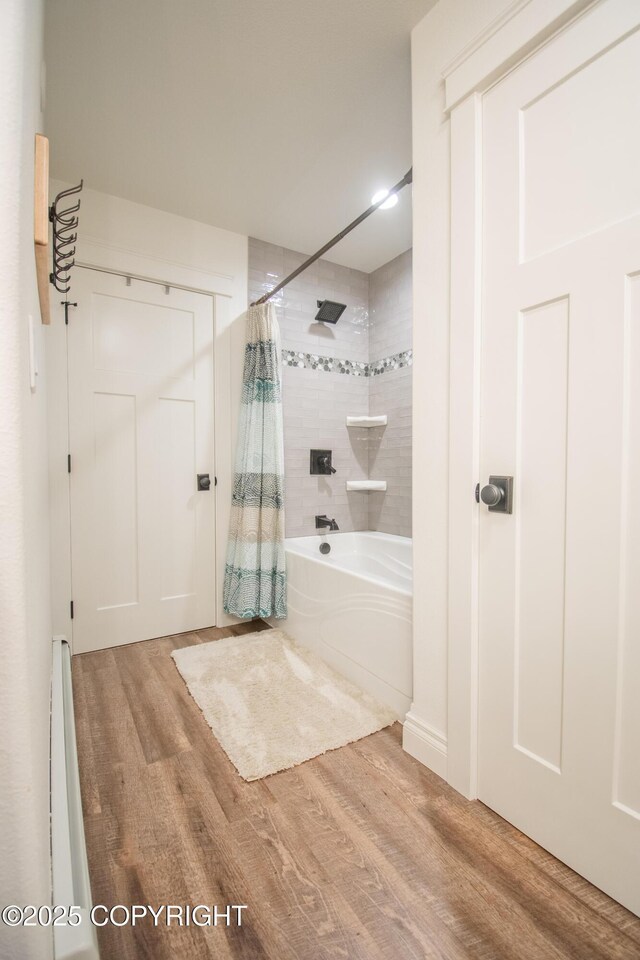 bathroom featuring shower / bathtub combination with curtain and wood finished floors