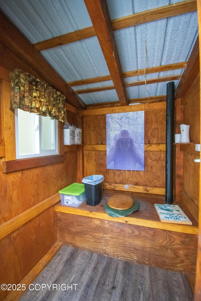 interior details with beam ceiling, wood walls, and wood finished floors