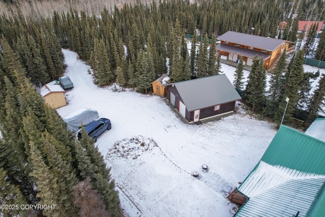 snowy aerial view featuring a forest view