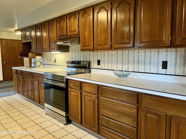 2707 W 31st Ave, Anchorage, AK 99517 - kitchen with stainless steel electric range oven, under cabinet range hood, and light countertops