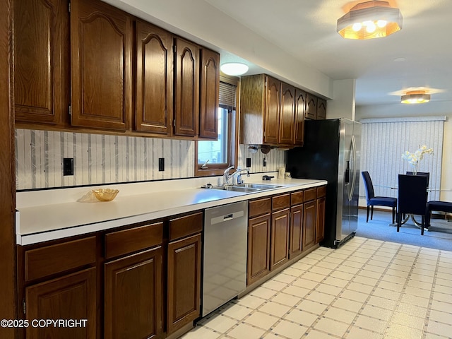 2707 W 31st Ave, Anchorage, AK 99517 - kitchen featuring stainless steel appliances, a sink, light countertops, light floors, and dark brown cabinetry