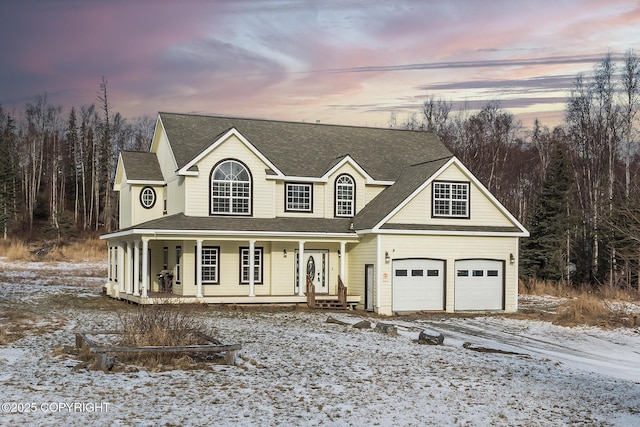 view of front of property featuring a garage, driveway, a porch, and a shingled roof