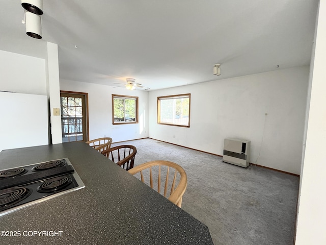 carpeted dining room with heating unit and ceiling fan