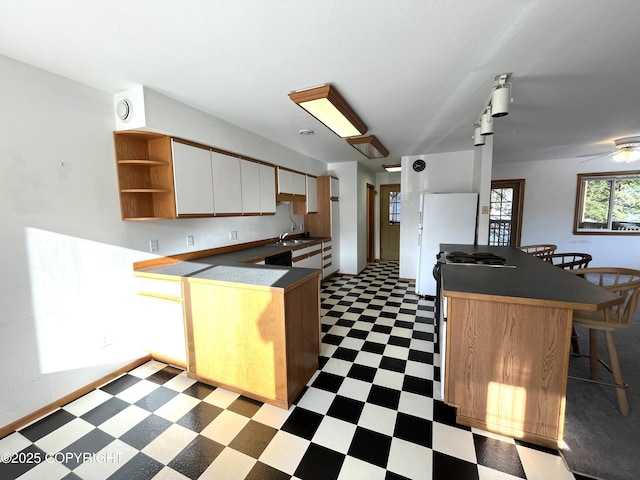 kitchen featuring white cabinetry, a breakfast bar, sink, and kitchen peninsula