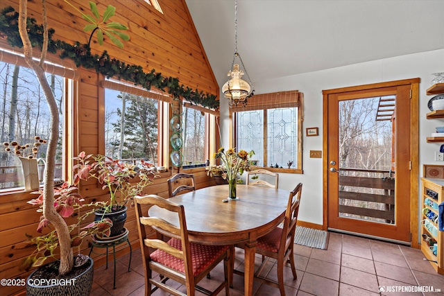 dining space with high vaulted ceiling, plenty of natural light, and light tile patterned floors