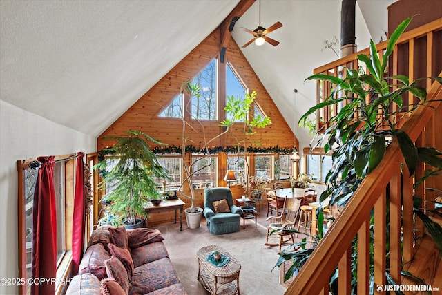 living area with high vaulted ceiling, beamed ceiling, and carpet flooring